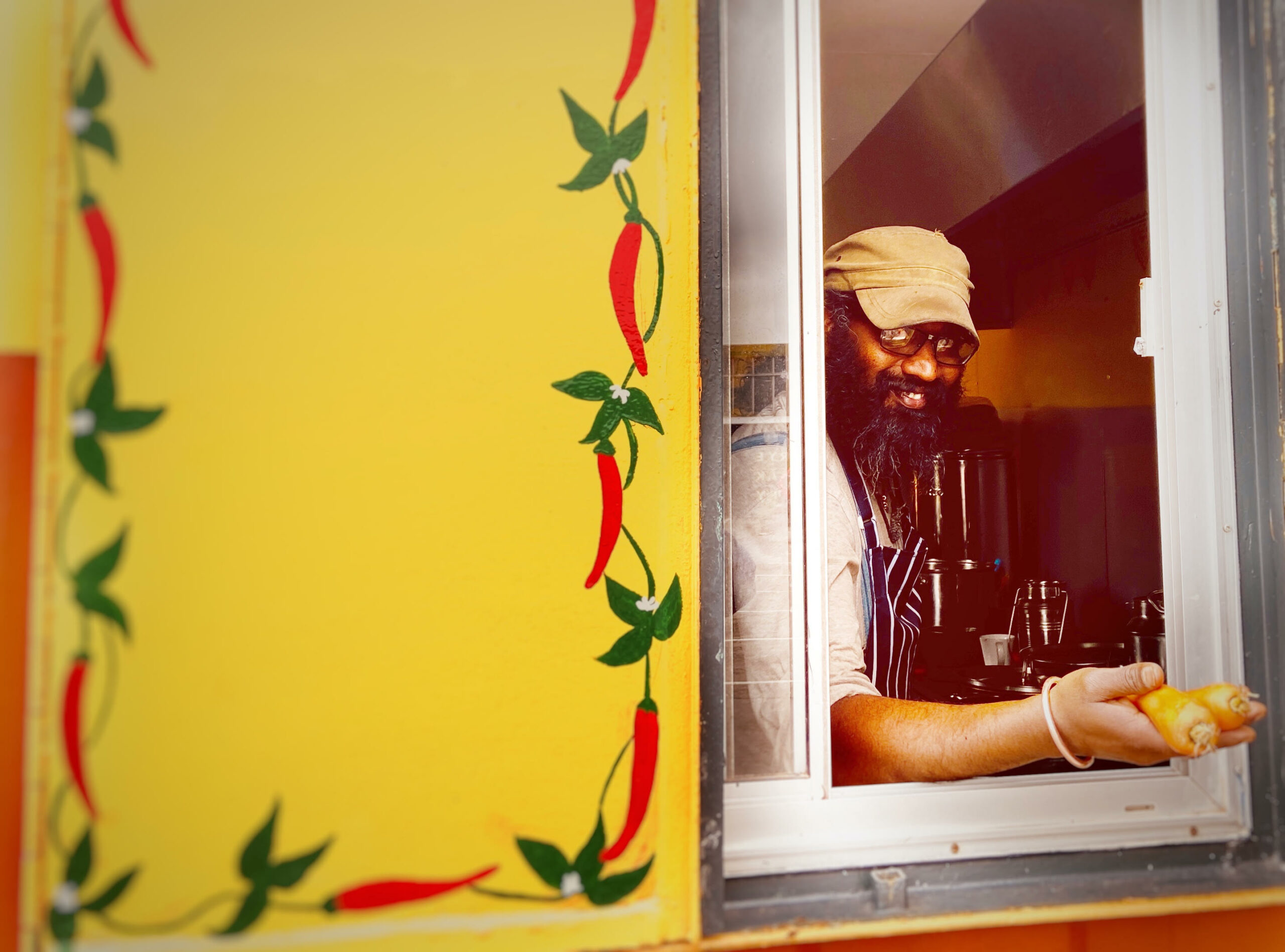 Chef looking through hatch on orange container where 11 chillies is